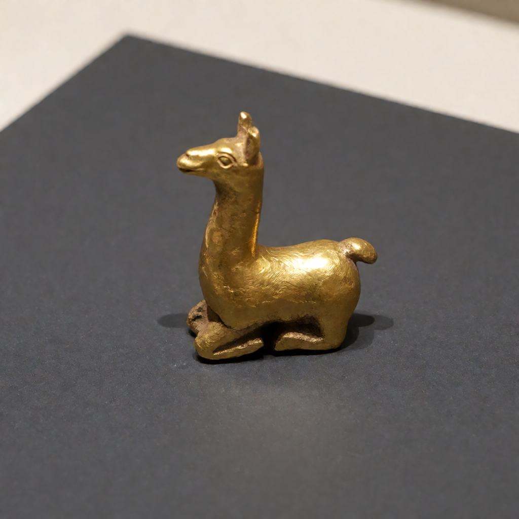 Small Inca cast gold llama figurine with a long neck and folded legs