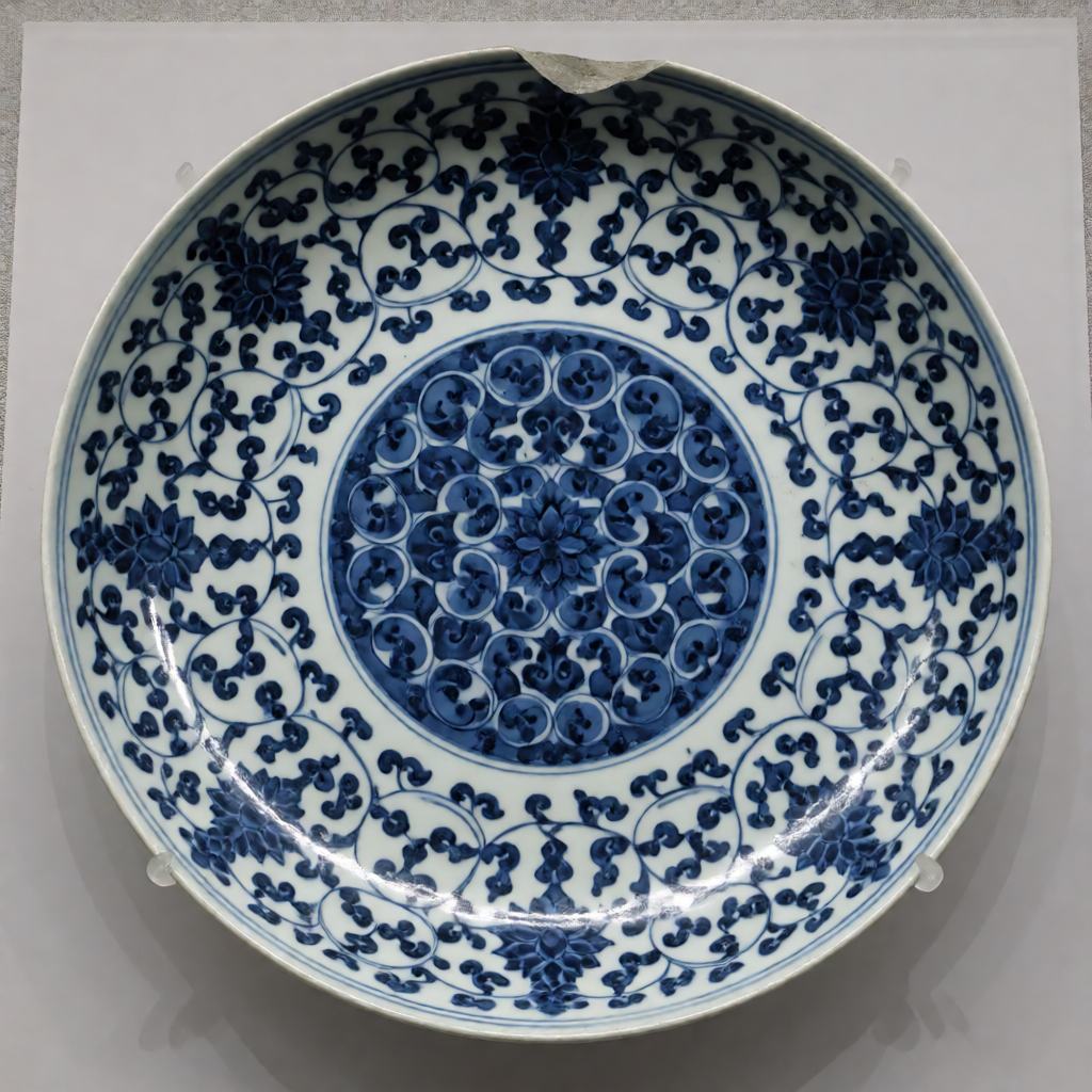 Blue and white porcelain plate with dense painted scrollwork in cobalt